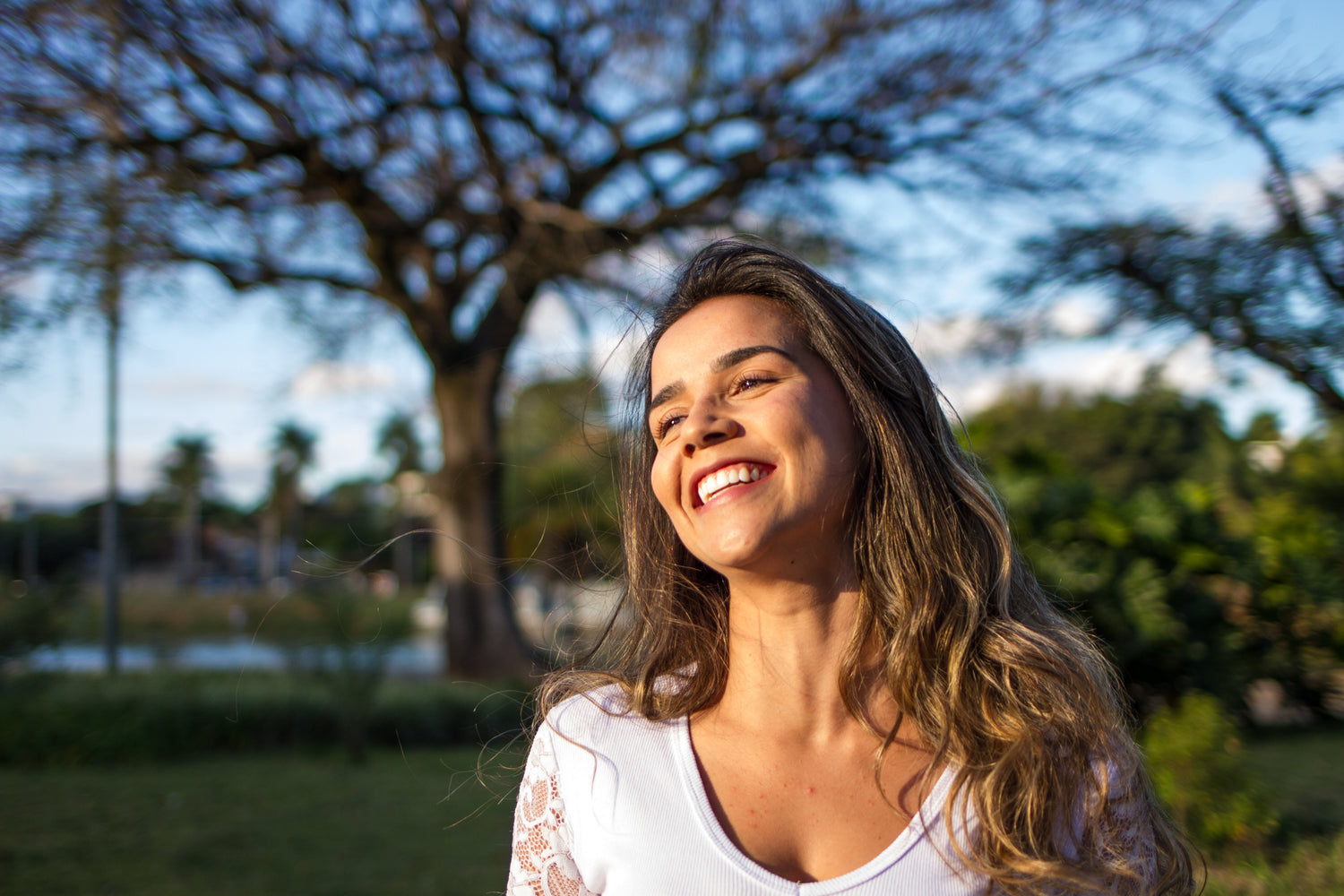 A young lady smiling with a blurry tree behind her