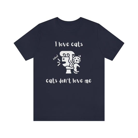 A navy colored t-shirt showing a woman looking away from a cat sneezing, with the text "I love cats, cats don't love me"