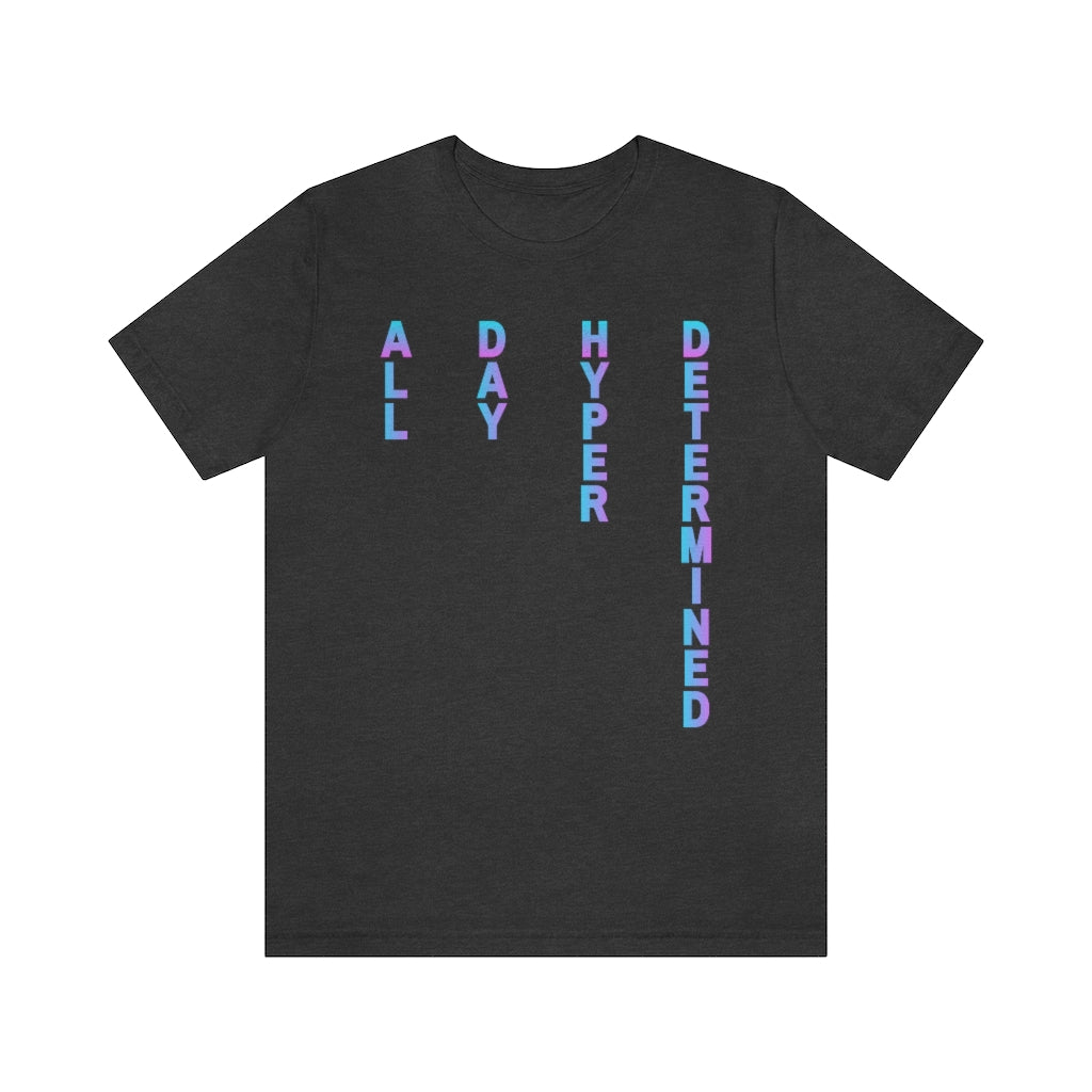 A dark grey heather colored T-shirt, text on it goes from top to bottom fading from blue to purple reading: All Day Hyper Determined