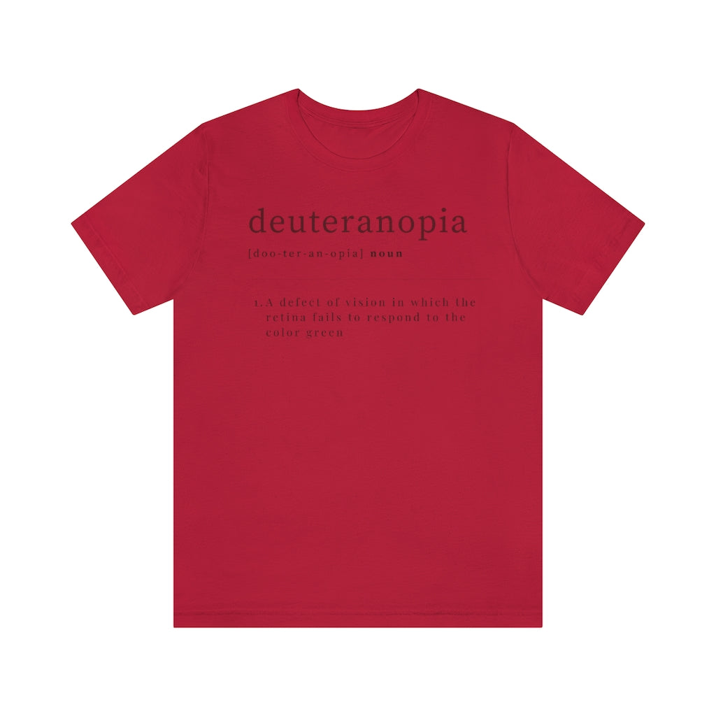A red t-shirt with text laid out like a dictionary. It reads in black letters: "Deuteranopia, noun. A defect of vision in which the retina fails to respond to the color green."
