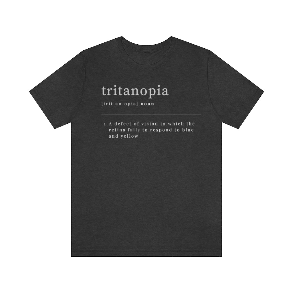 A dark grey heather t-shirt with text laid out like a dictionary. It reads in white letters: "Tritanopia, noun. A defect of vision in which the retina fails to respond to blue and yellow.