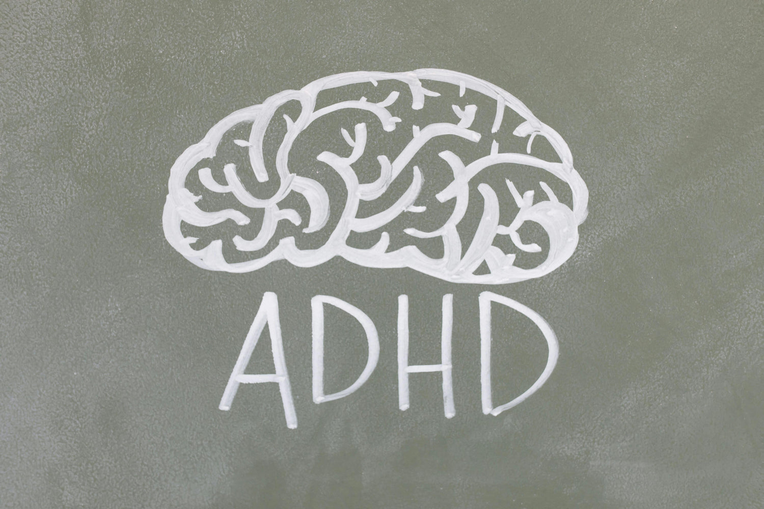 A chalk-drawn brain with ADHD written under it