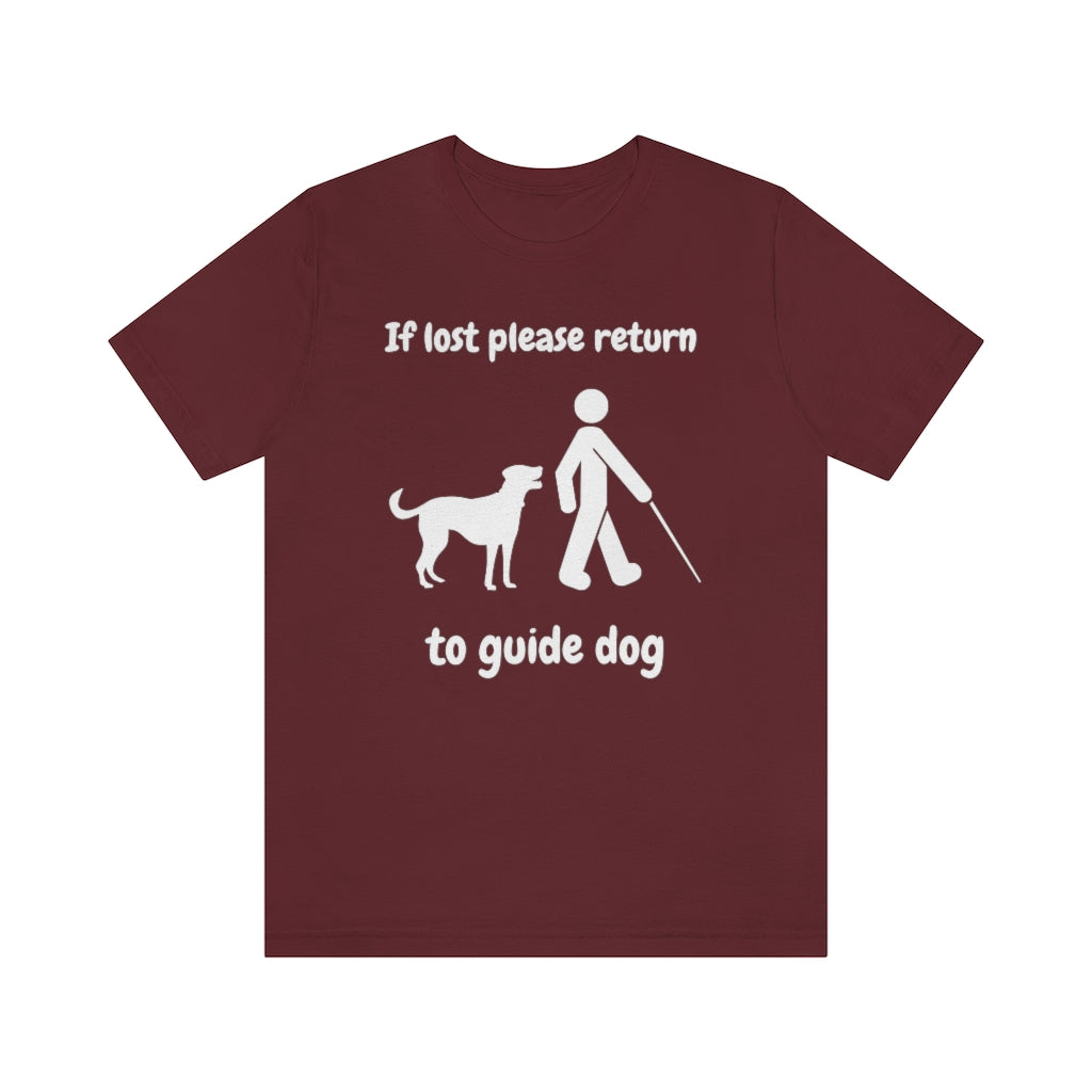 A maroon colored t-shirt with the text "If lost please return to guide dog",with a picture of a man with a cane walking away from a dog.