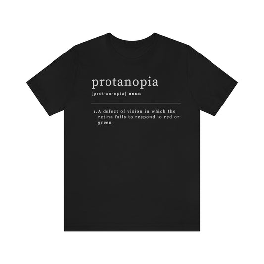 A black t-shirt with text laid out like a dictionary. It reads in white letters: "protanopia, noun. A defect of vision in which the retina fails to respond to red or green."