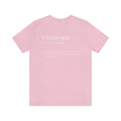 A pink t-shirt with text laid out like a dictionary. It reads in white letters: "Tritanopia, noun. A defect of vision in which the retina fails to respond to blue and yellow.