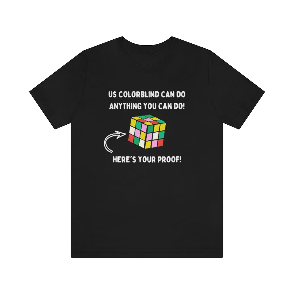 Black t-shirt showing in white text: "Us colorblind can do anything you can do! Here's your proof!" with an arrow pointing to a wrongly-solved rubix cube.
