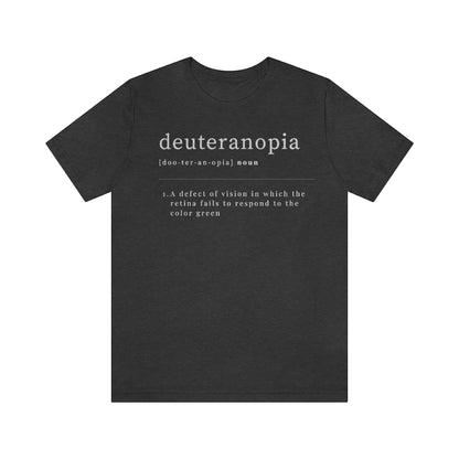 A dark grey heather t-shirt with text laid out like a dictionary. It reads in white letters: "Deuteranopia, noun. A defect of vision in which the retina fails to respond to the color green."