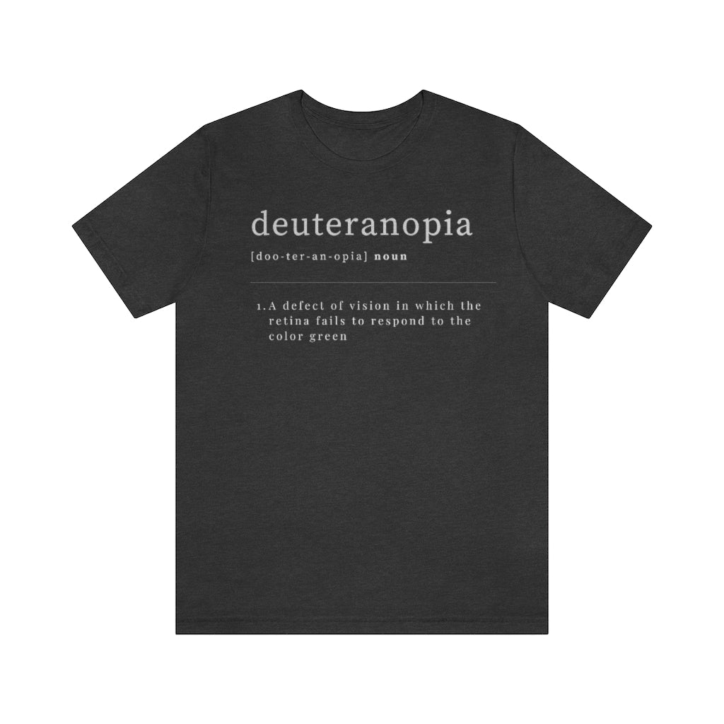 A dark grey heather t-shirt with text laid out like a dictionary. It reads in white letters: "Deuteranopia, noun. A defect of vision in which the retina fails to respond to the color green."