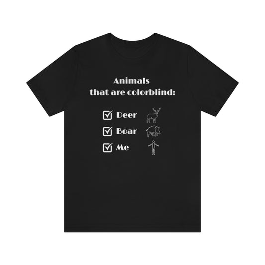 A black T-shirt with white text reading: "Animals that are colorblind:". Under it are 3 checked boxes with the words "Deer", "Boar" and "Me". Behind these are outline drawings showing the animals and a human.