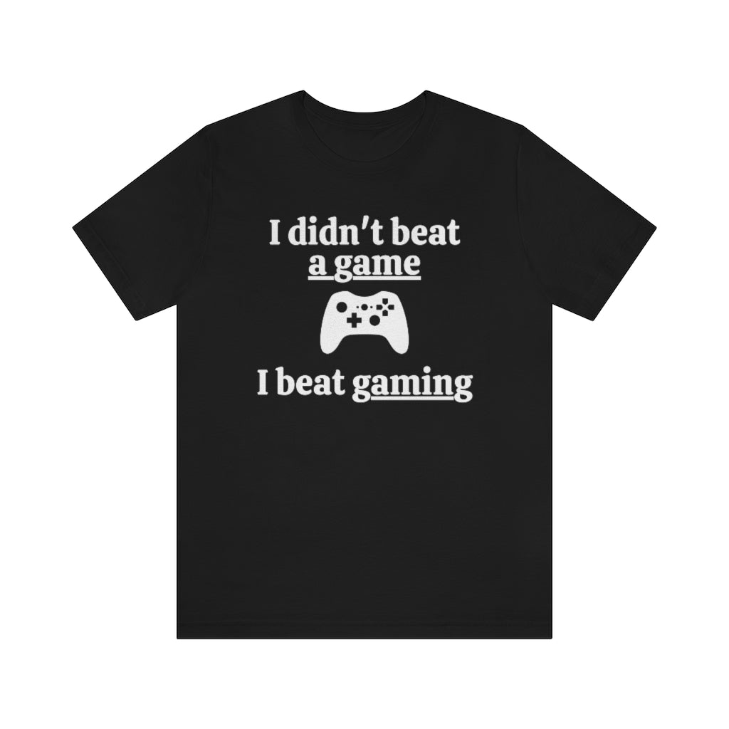 Black t-shirt with white text saying "I didn't beat a game, I beat gaming". With an iamge of an xbox controller in the middle. 