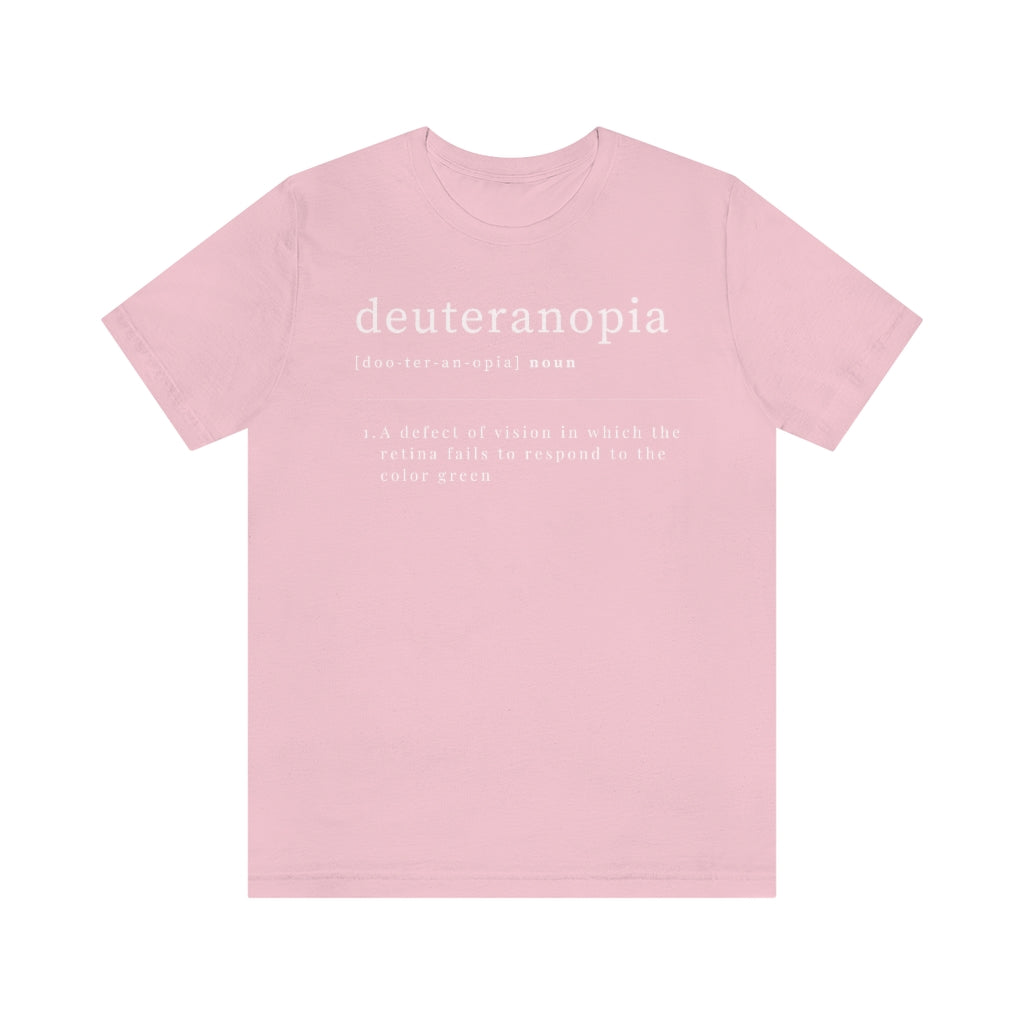 A pink t-shirt with text laid out like a dictionary. It reads in white letters: "Deuteranopia, noun. A defect of vision in which the retina fails to respond to the color green."