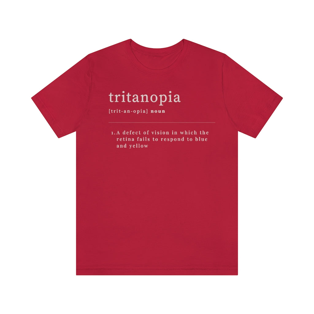 A red t-shirt with text laid out like a dictionary. It reads in white letters: "Tritanopia, noun. A defect of vision in which the retina fails to respond to blue and yellow.