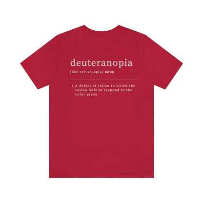 A red t-shirt with text laid out like a dictionary. It reads in white letters: "Deuteranopia, noun. A defect of vision in which the retina fails to respond to the color green."