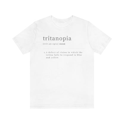 A white t-shirt with text laid out like a dictionary. It reads in black letters: "Tritanopia, noun. A defect of vision in which the retina fails to respond to blue and yellow.