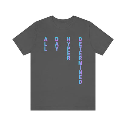An asphalt colored T-shirt, text on it goes from top to bottom fading from blue to purple reading: All Day Hyper Determined
