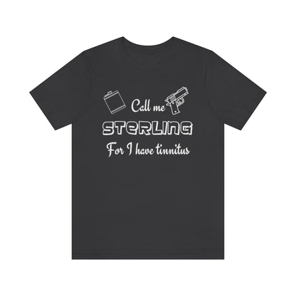 A dark grey-colored t-shirt with in white "Call me Sterling for I have tinnitus" with a gun and alcohol flask outlined. 