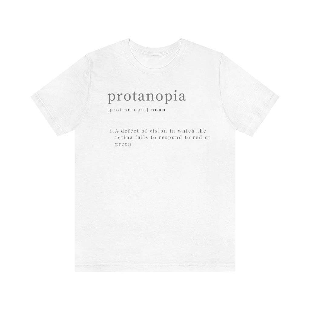 A white t-shirt with text laid out like a dictionary. It reads in black letters: "protanopia, noun. A defect of vision in which the retina fails to respond to red or green."
