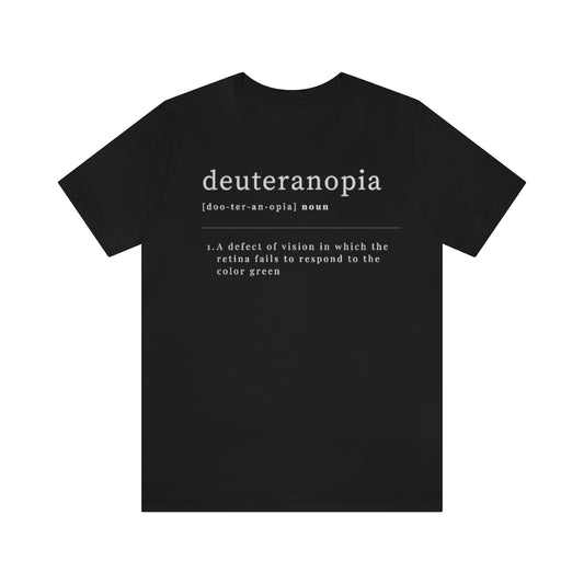 A black t-shirt with text laid out like a dictionary. It reads in white letters: "Deuteranopia, noun. A defect of vision in which the retina fails to respond to the color green."