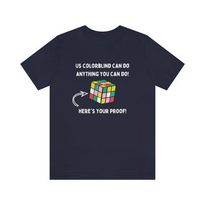 A navy colored t-shirt showing in white text: "Us colorblind can do anything you can do! Here's your proof!" with an arrow pointing to a wrongly-solved rubix cube.