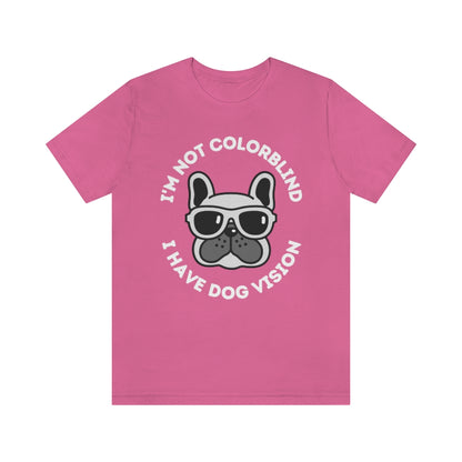A pink t-shirt with an image of a bulldog wearing sunglasses. Around it the text "I'm not colorblind, I have dog vision".
