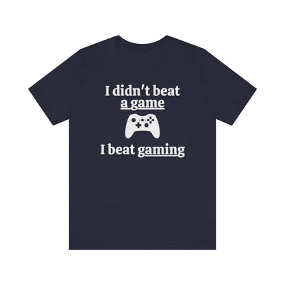 Navy t-shirt with white text saying "I didn't beat a game, I beat gaming". With an iamge of an xbox controller in the middle. 