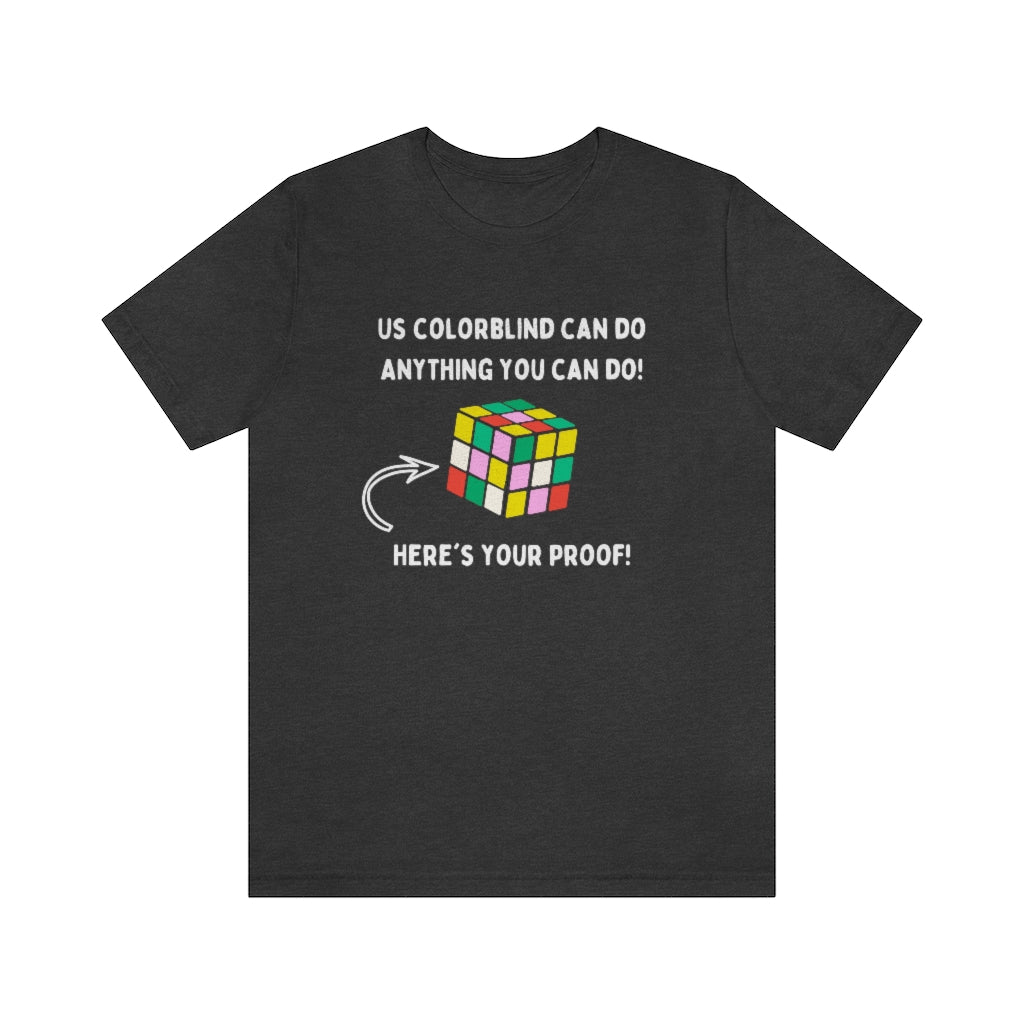 A dark gray heather t-shirt showing in white text: "Us colorblind can do anything you can do! Here's your proof!" with an arrow pointing to a wrongly-solved rubix cube.
