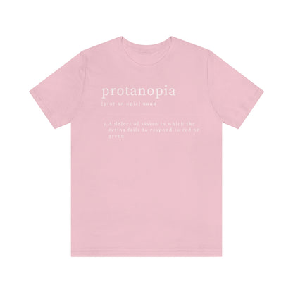A pink t-shirt with text laid out like a dictionary. It reads in white letters: "protanopia, noun. A defect of vision in which the retina fails to respond to red or green."