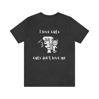 A dark gray heather colored t-shirt showing a woman looking away from a cat sneezing, with the text "I love cats, cats don't love me"
