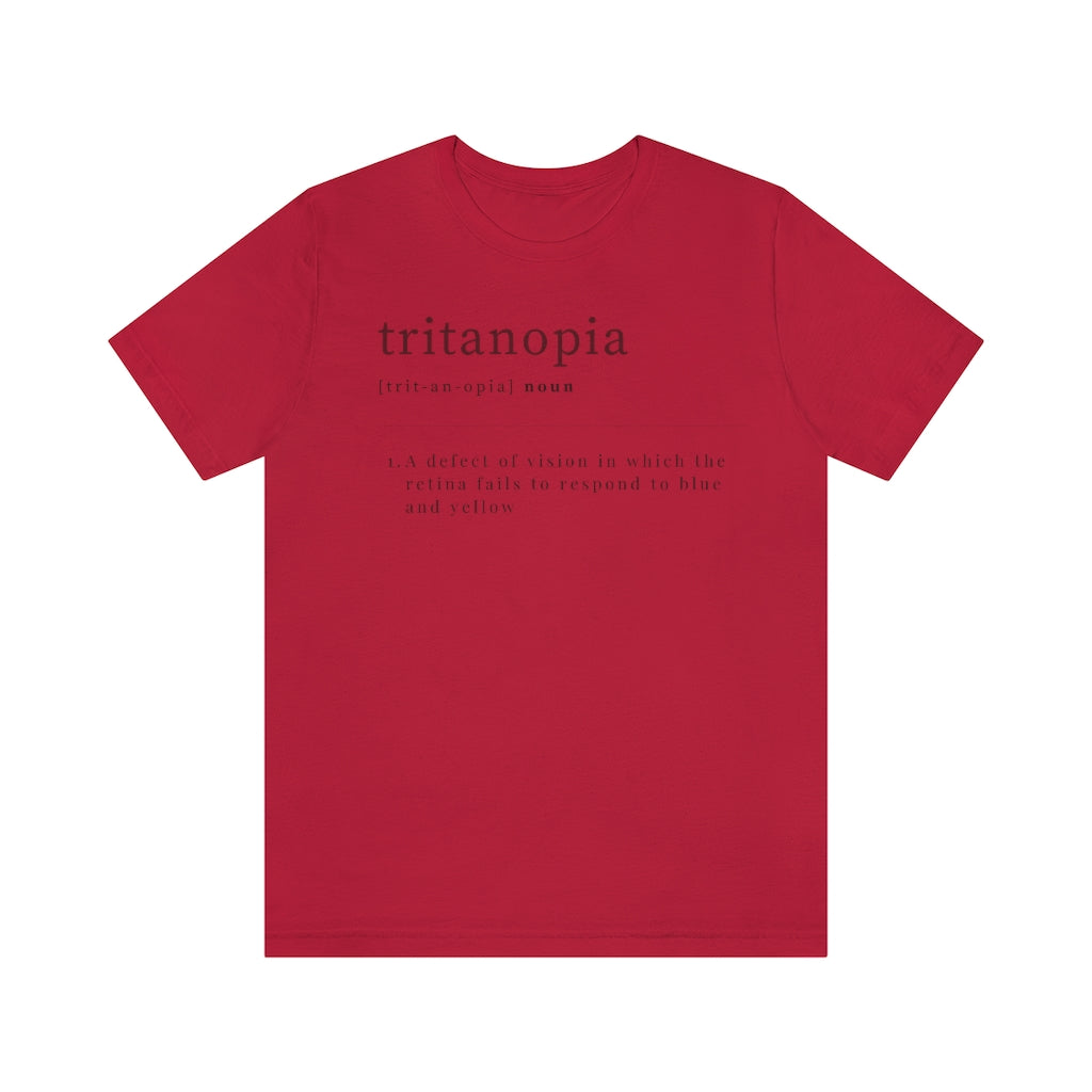 A red t-shirt with text laid out like a dictionary. It reads in black letters: "Tritanopia, noun. A defect of vision in which the retina fails to respond to blue and yellow.