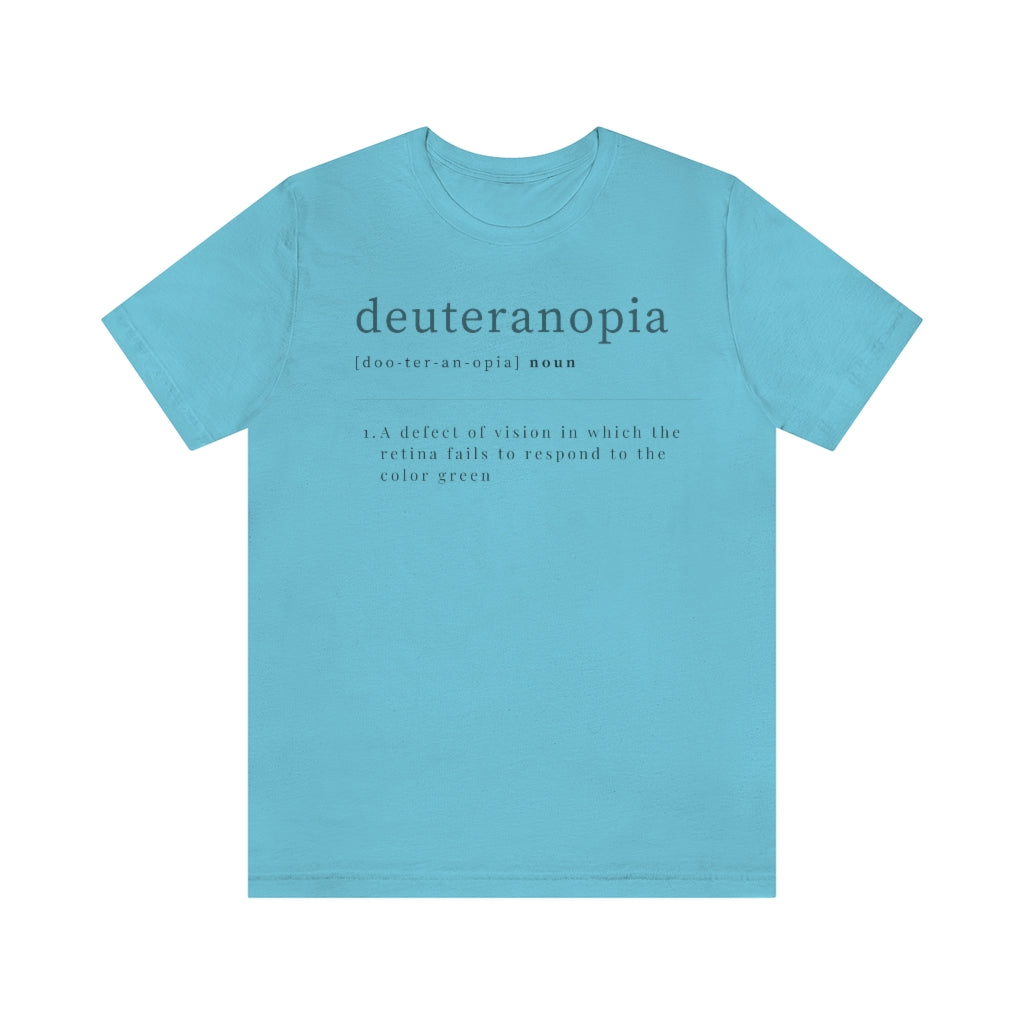 A turquoise t-shirt with text laid out like a dictionary. It reads in black letters: "Deuteranopia, noun. A defect of vision in which the retina fails to respond to the color green."